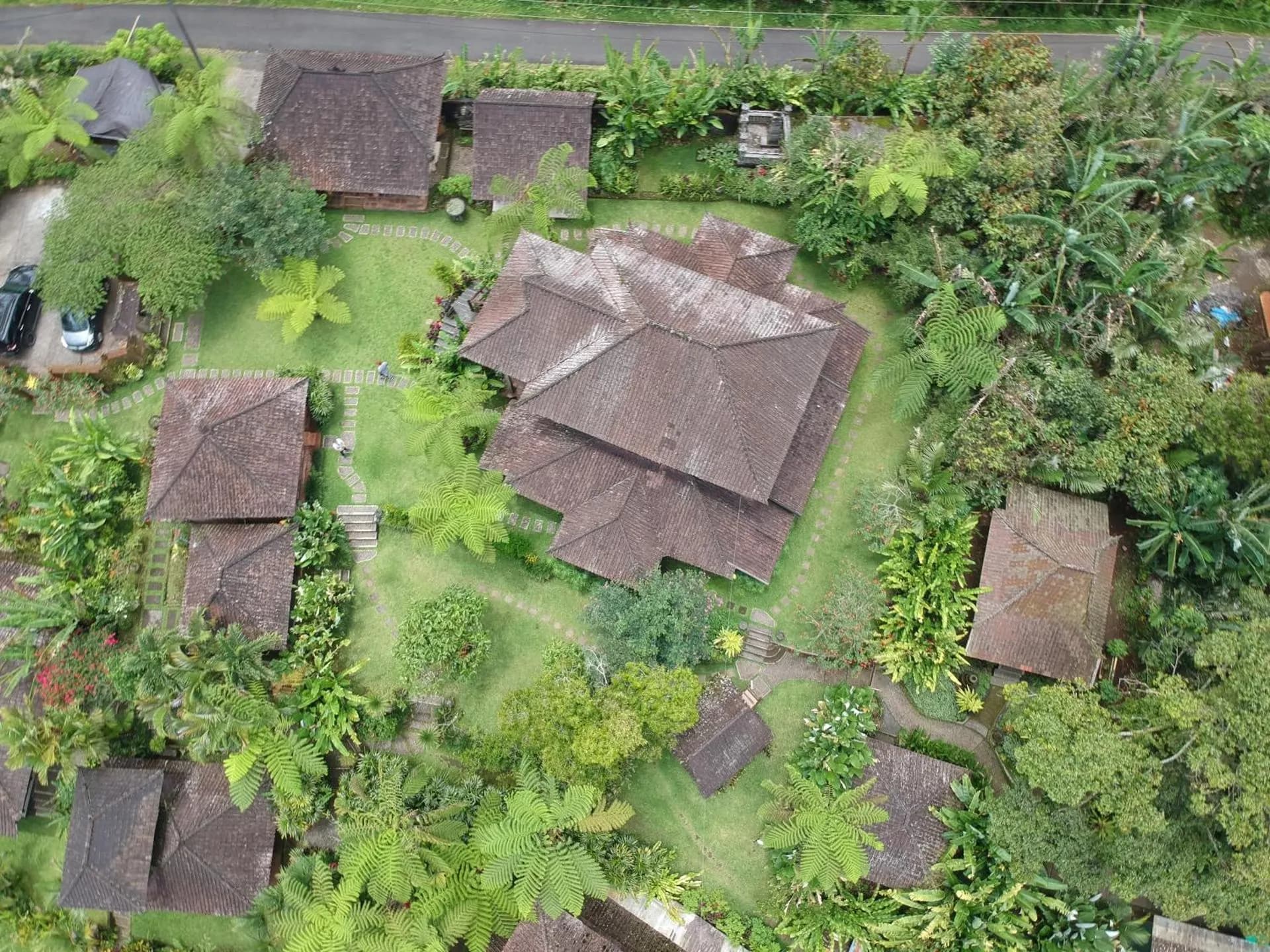 Aerial view of the retreat's tiled timber houses among the jungle