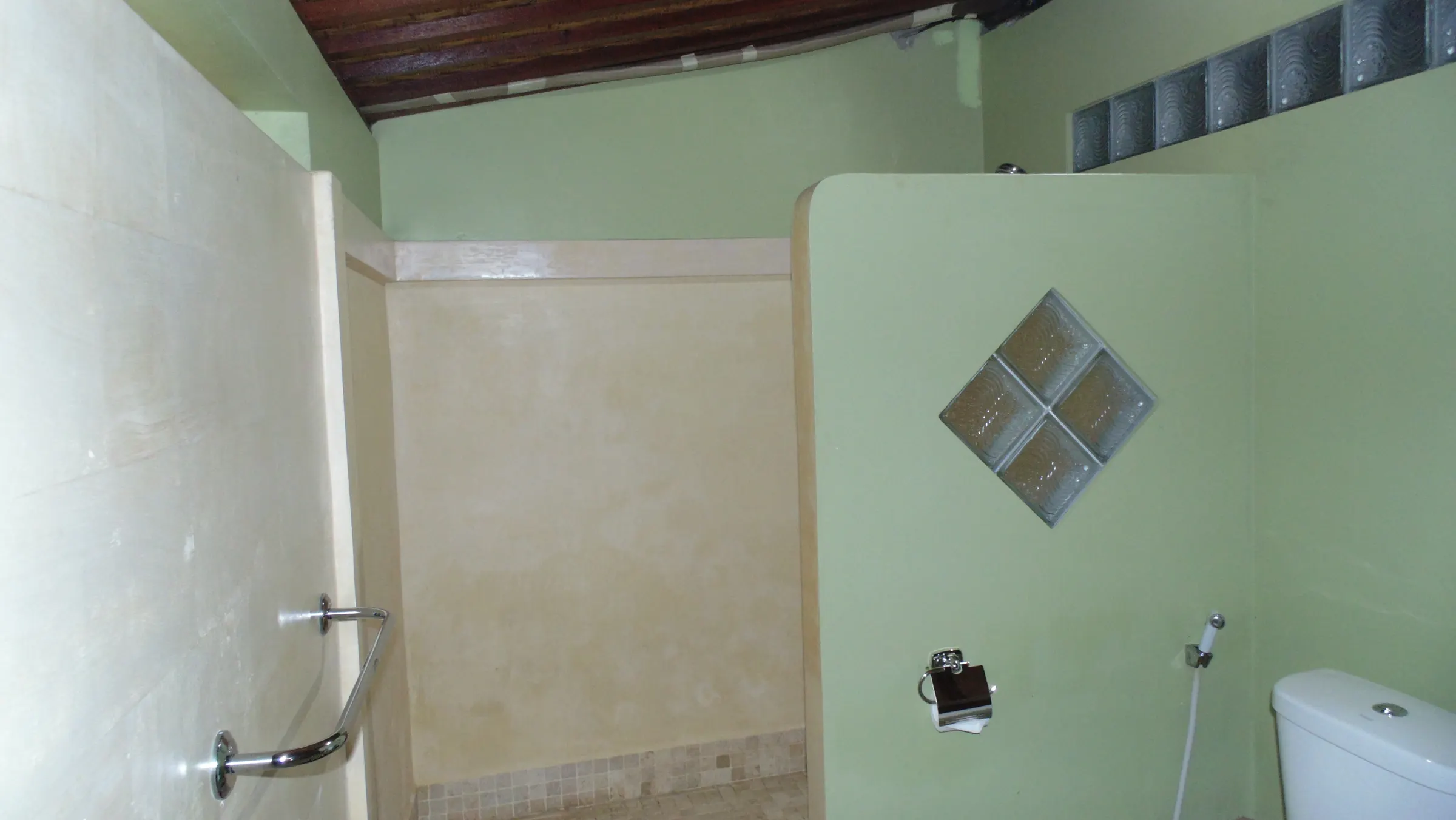The Deluxe Arjuna walk-in shower with a glass-block window