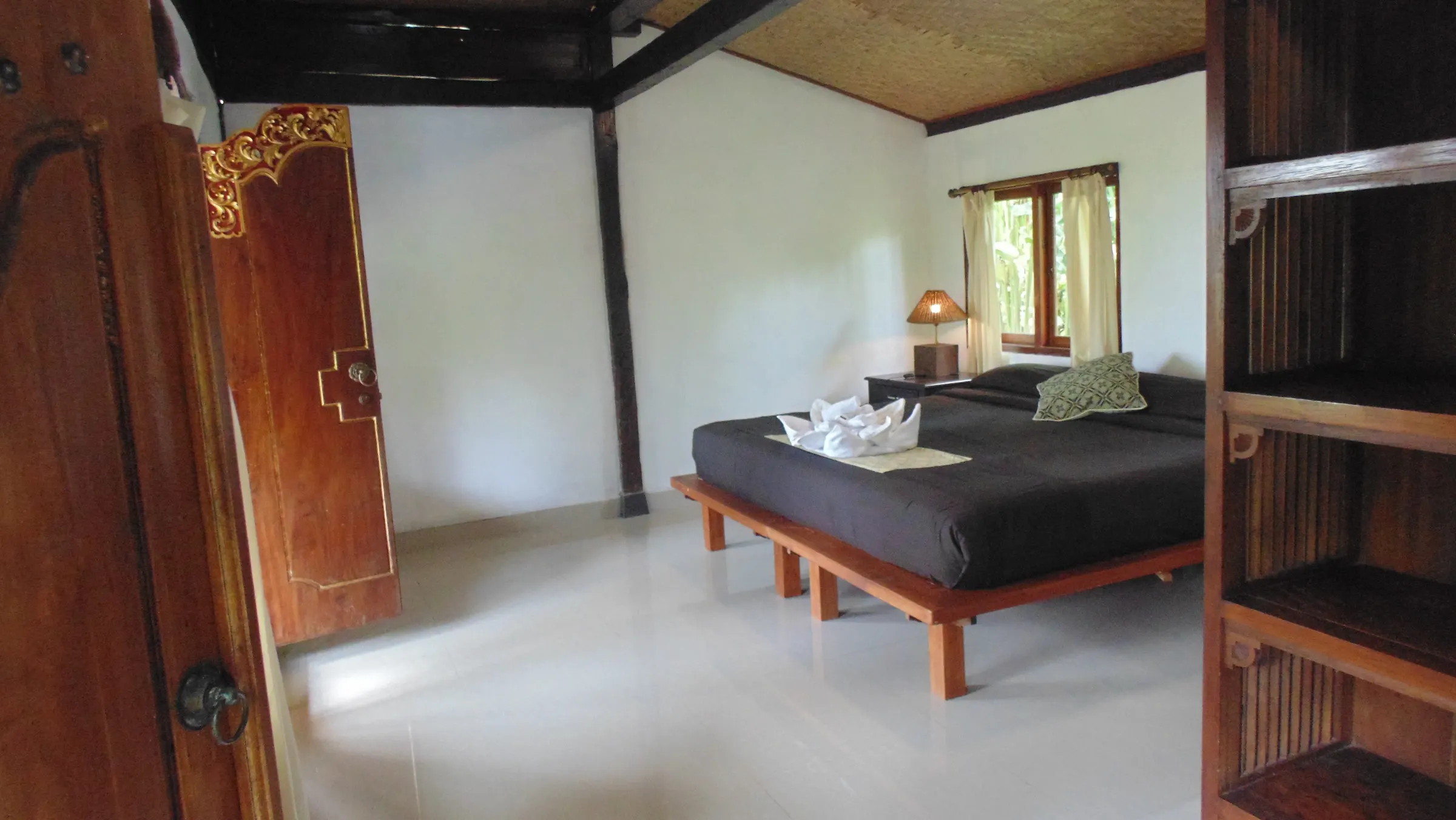 The Duren House bedroom seen through a carved, gilded teak door