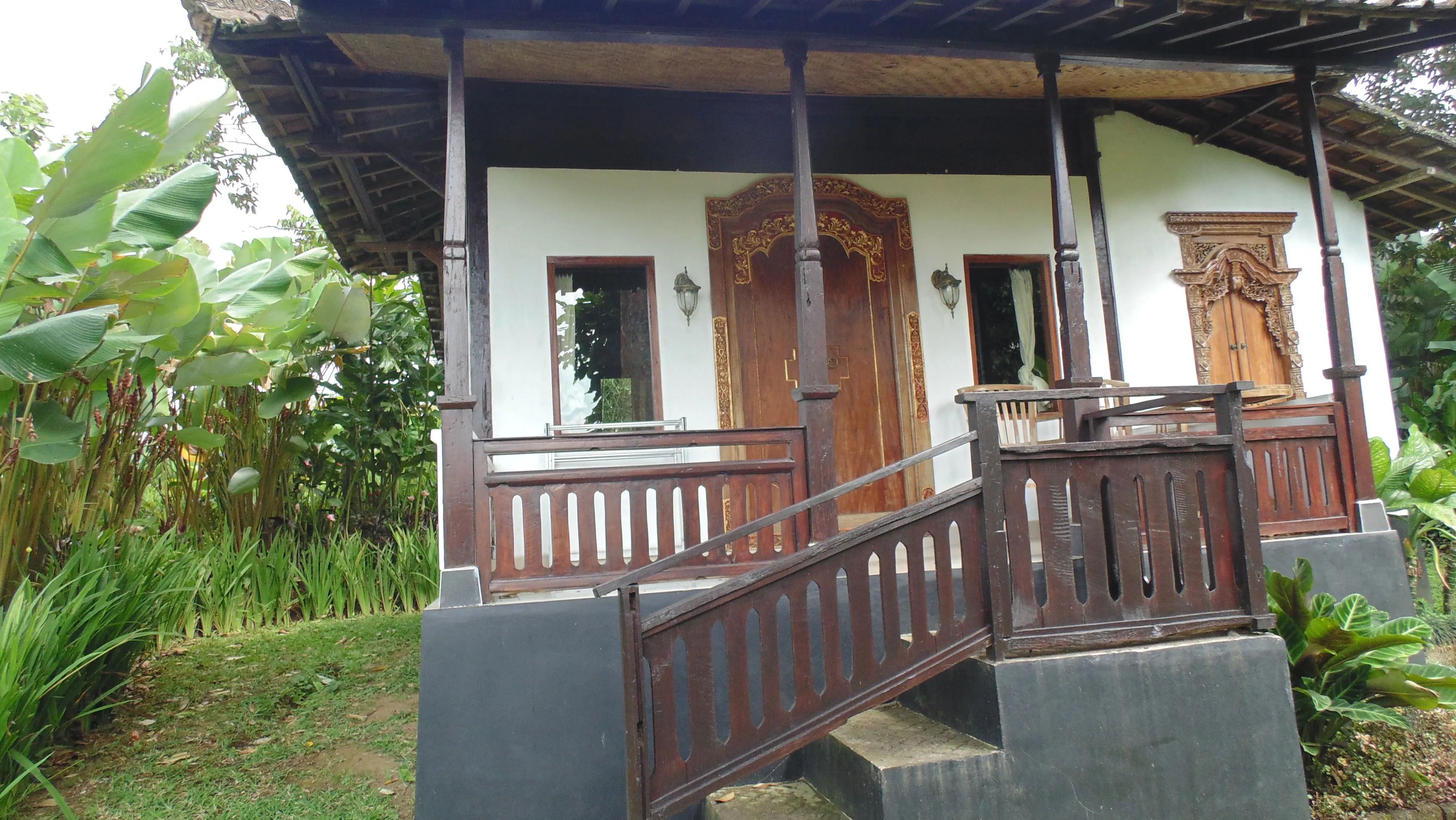 The Duren House veranda with its carved, gilded door and timber railings