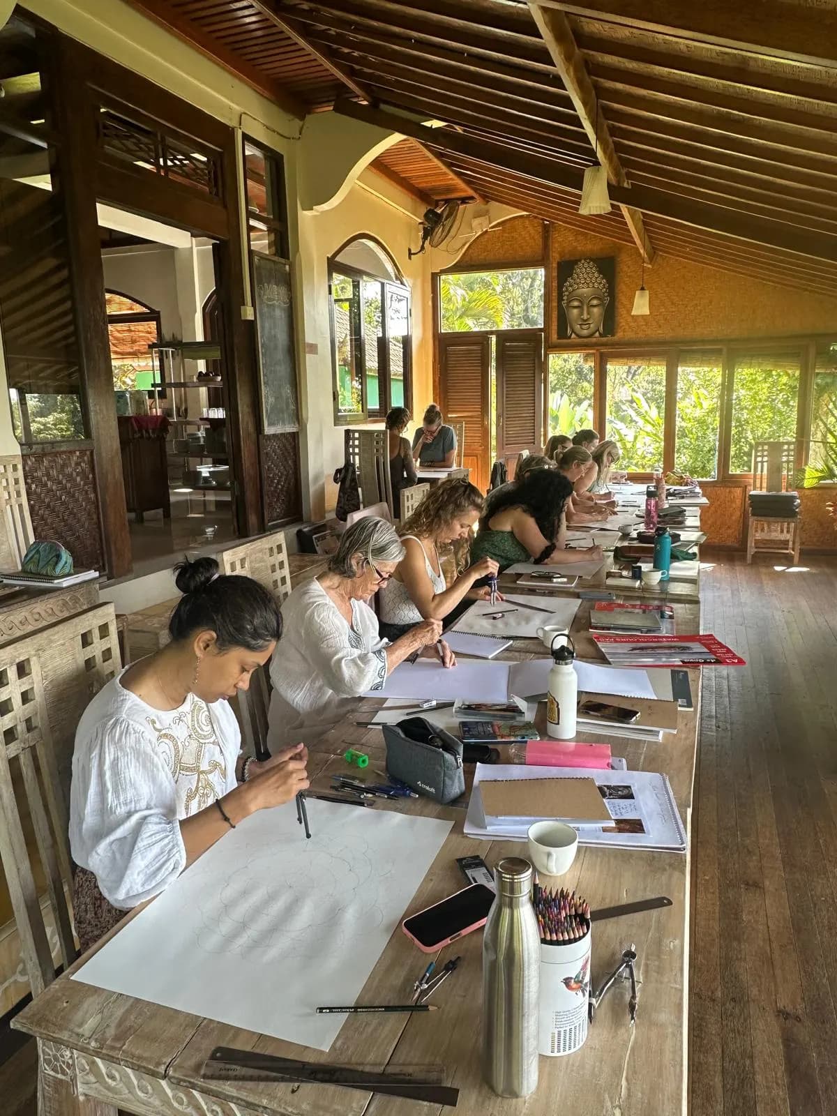 Drawing with compasses along a carved table in a sunlit timber hall