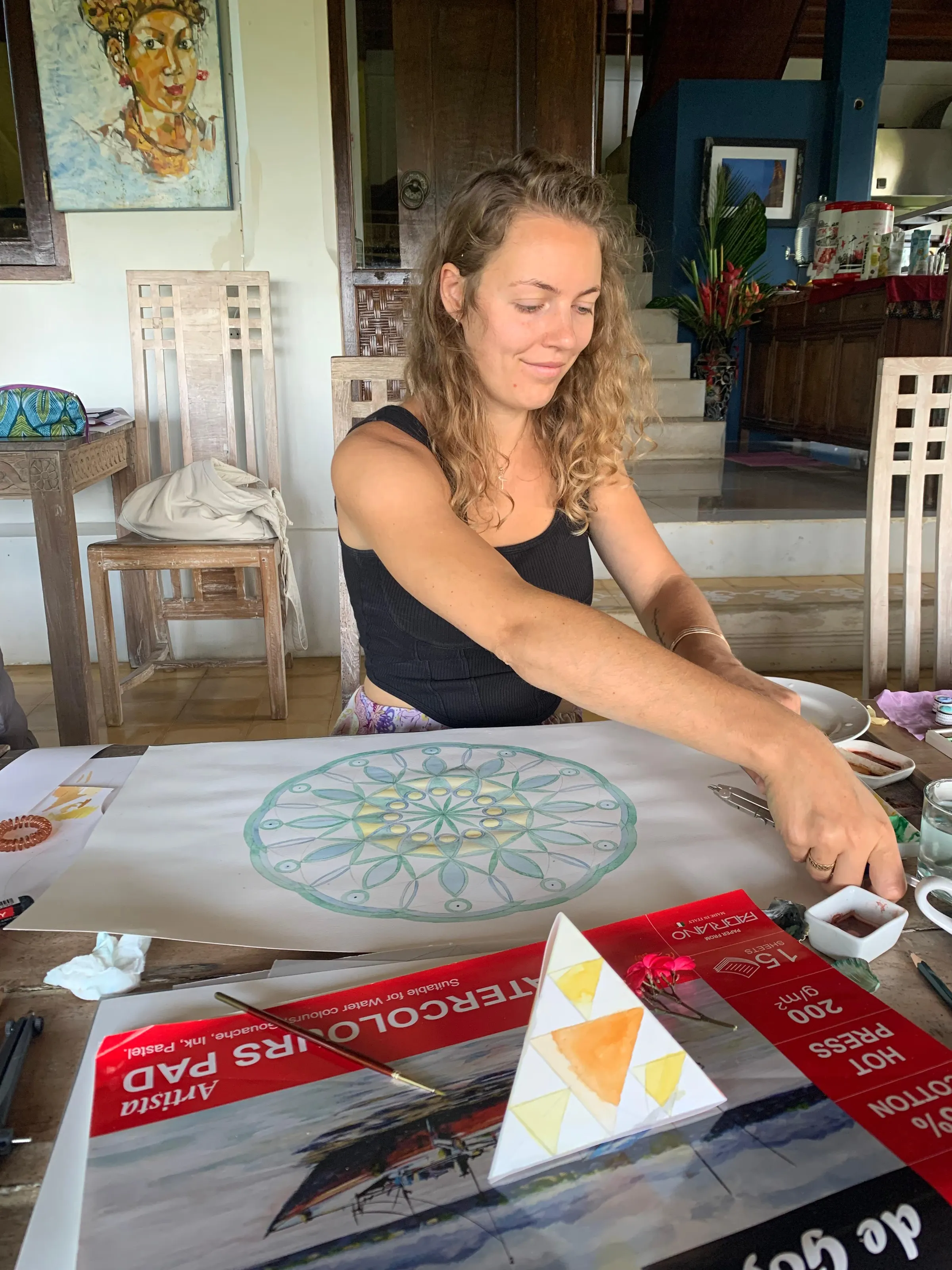 Painting a green and gold watercolour mandala beneath a Balinese dancer portrait