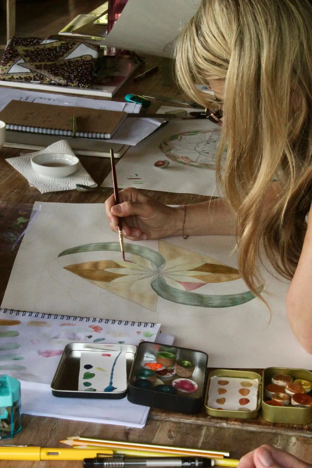 Painting a green and gold geometric design in watercolour