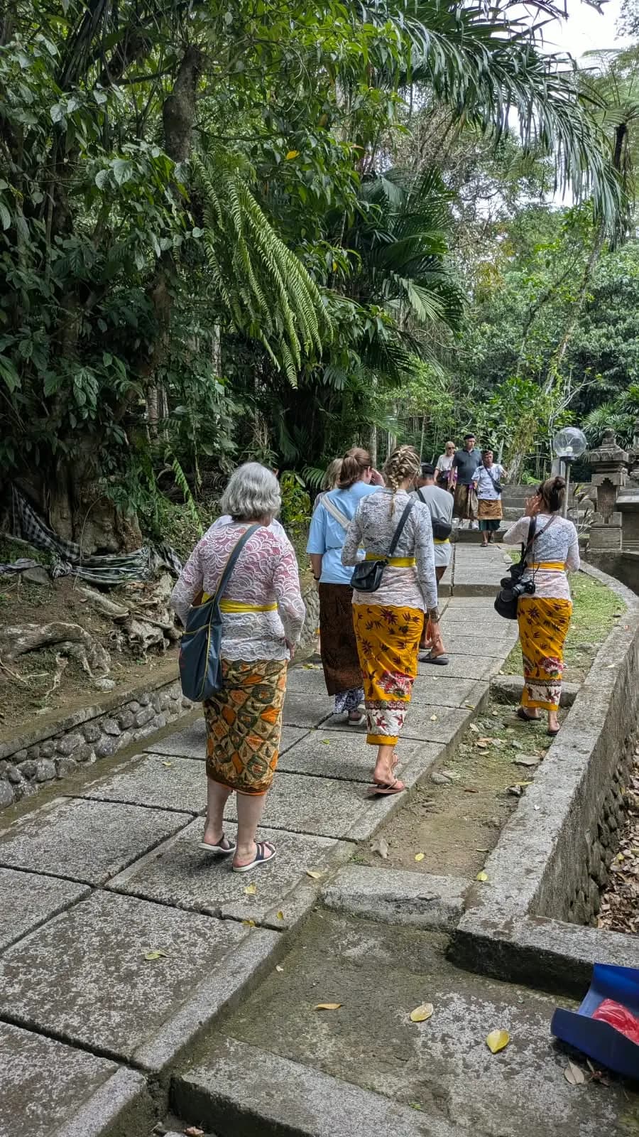 Walking a jungle-lined temple path in sarongs