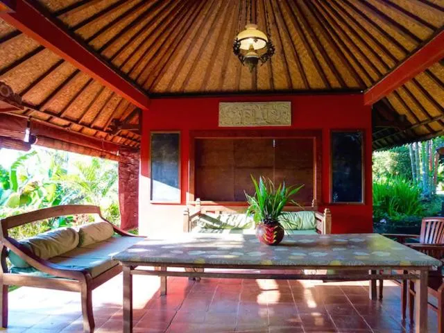 Open bale pavilion lounge with red walls and a daybed