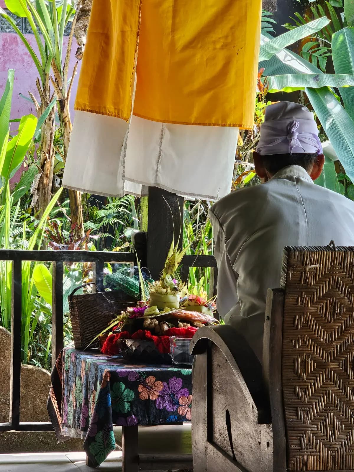 A tall Balinese offering of fruit, flowers and palm leaf