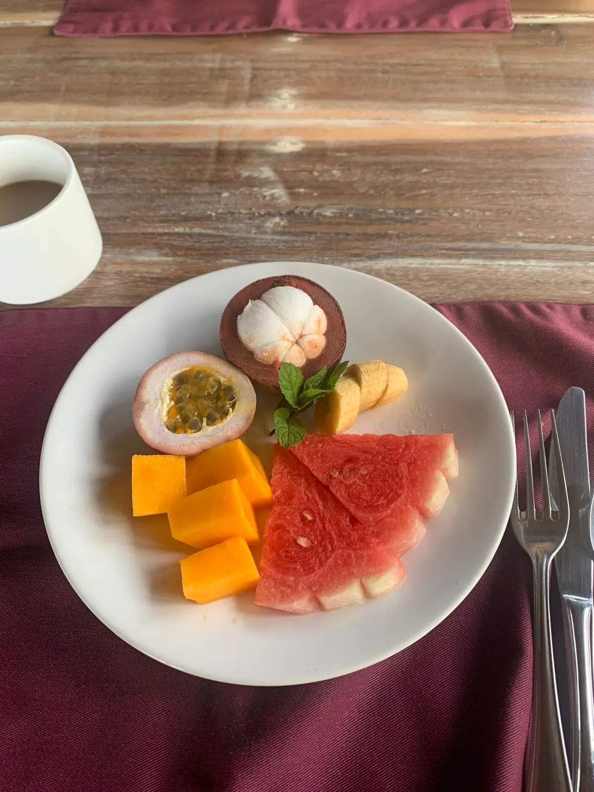 A breakfast plate of mangosteen, passion fruit, mango and watermelon