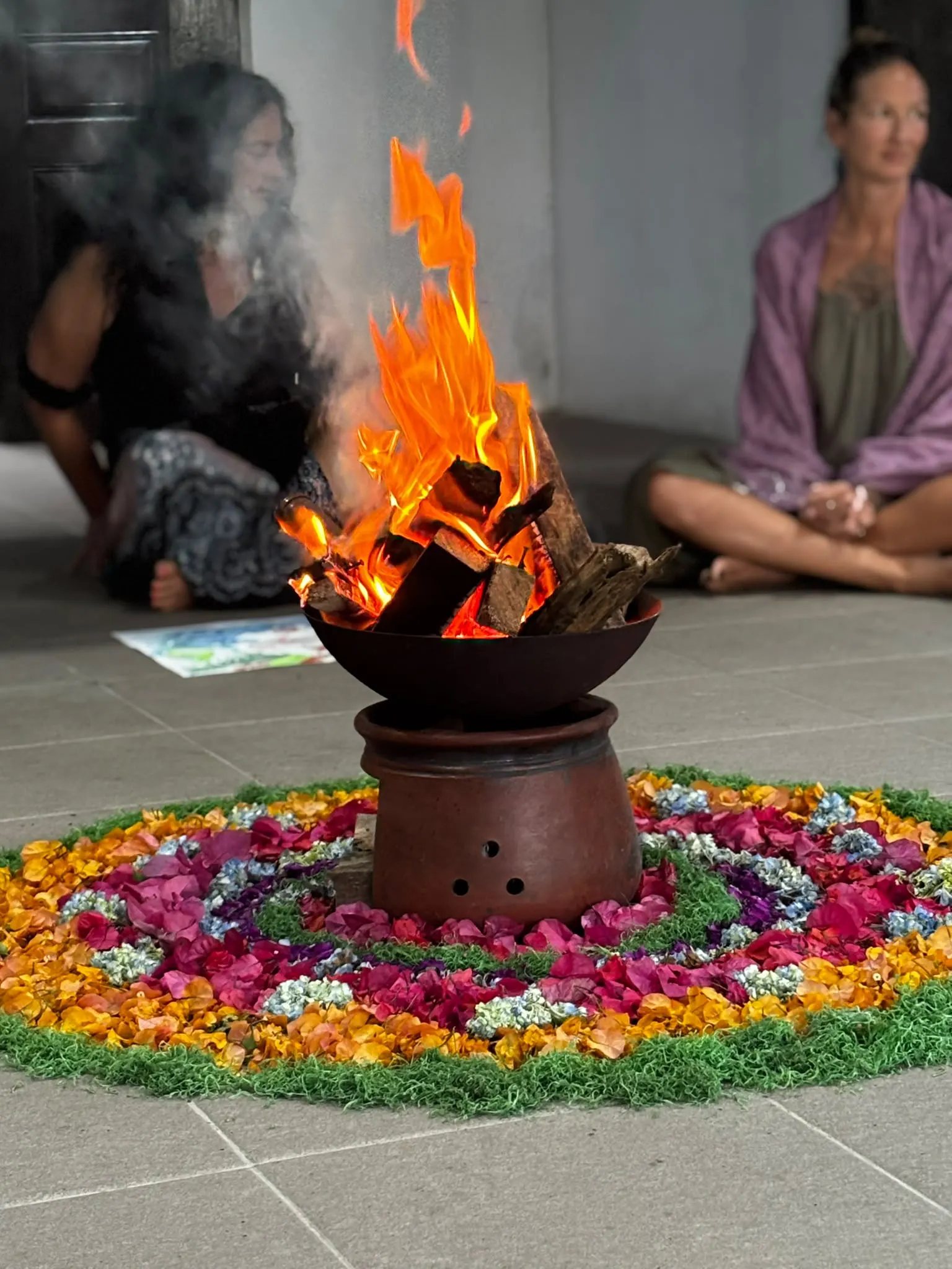 Flames rising from a fire pot set in a flower-petal mandala
