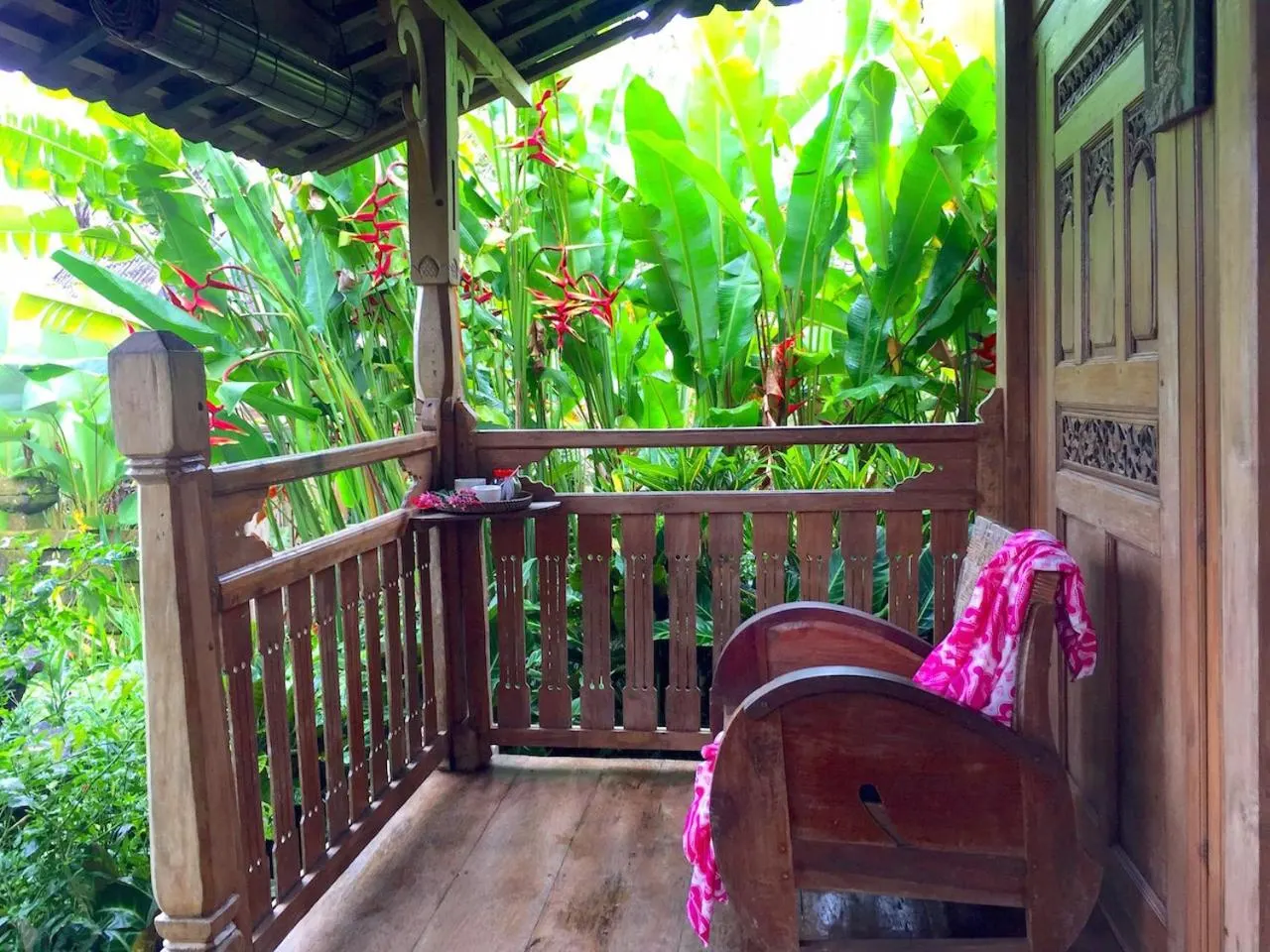 A private carved-teak veranda overlooking the garden